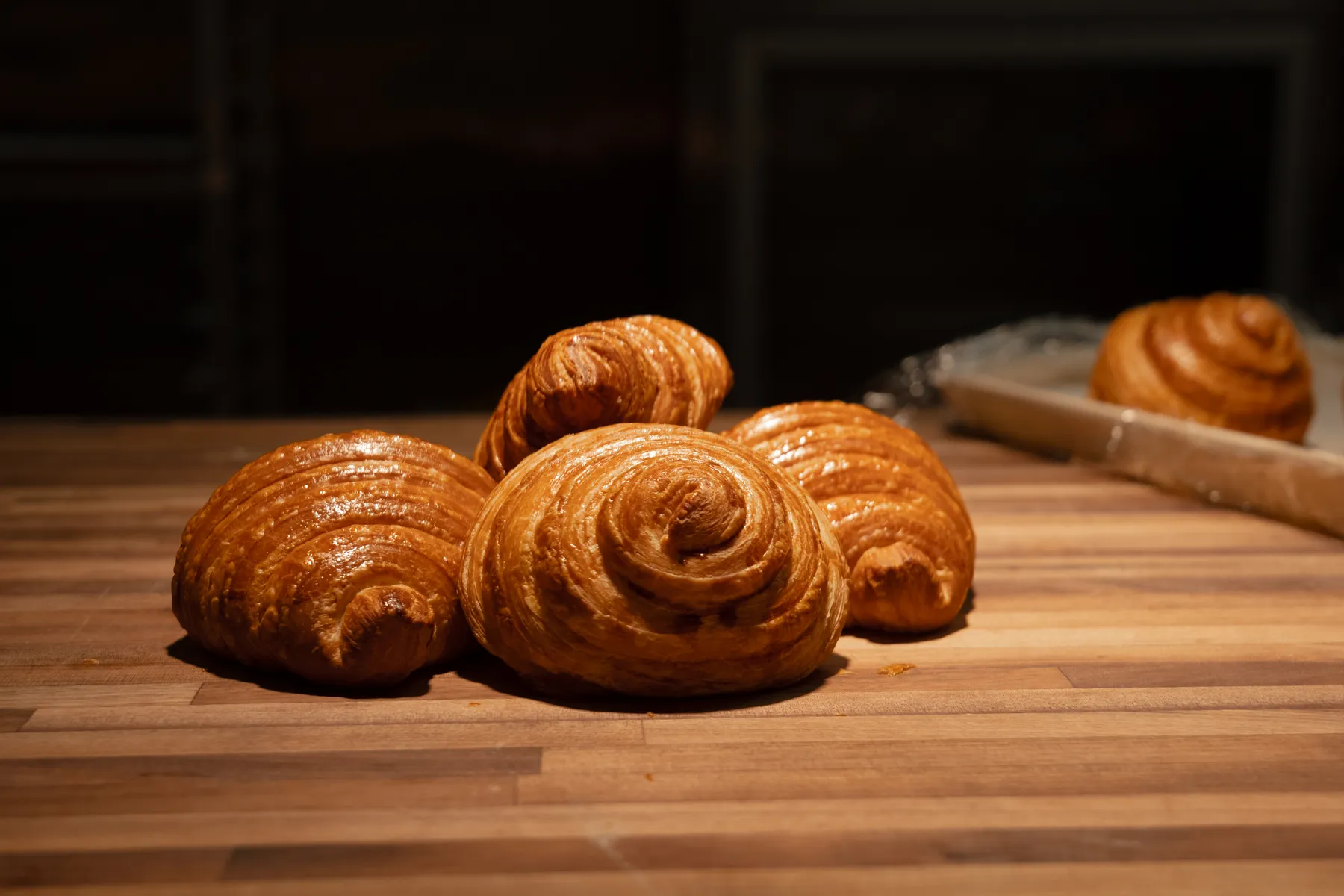 Display case filled with golden croissants and morning pastries